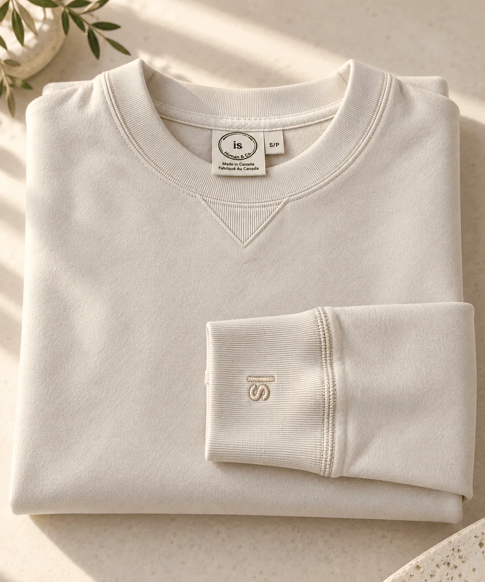 Human and Co. pearl sweatshirt with its embroidered cuff folded across the front